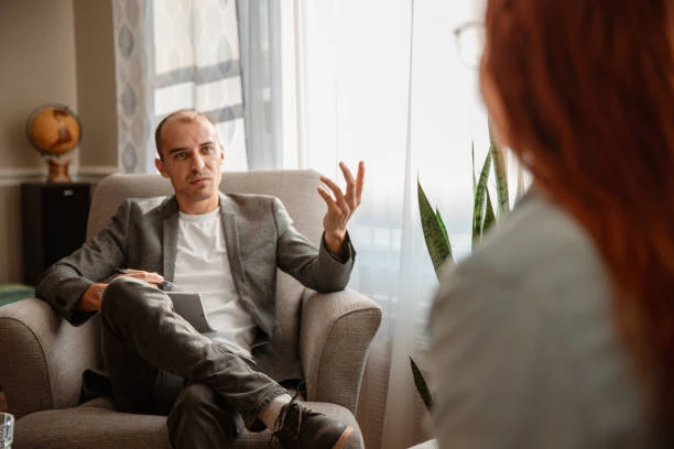 Male patient discussing depression symptoms with a therapist during a mental health consultation at Present Psychiatry in Houston, TX.